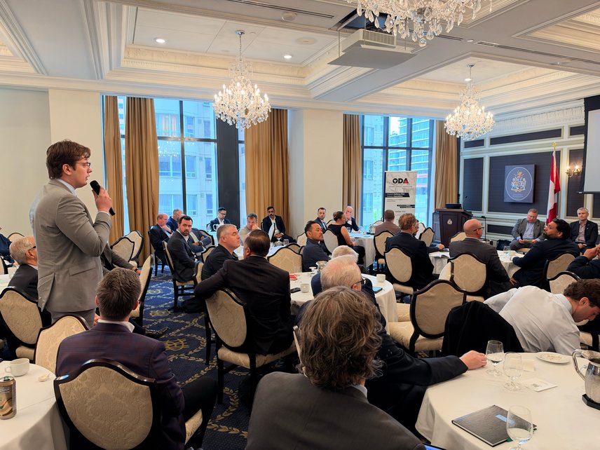An attendee standing to ask a question during a panel in the Otter Room