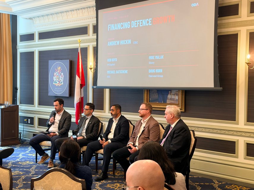 Five capital panellists seated on stage beneath a screen titled Financing Defence Growth